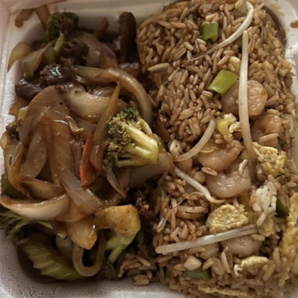 Chinese takeout container with beef and broccoli stir-fry and shrimp fried rice.